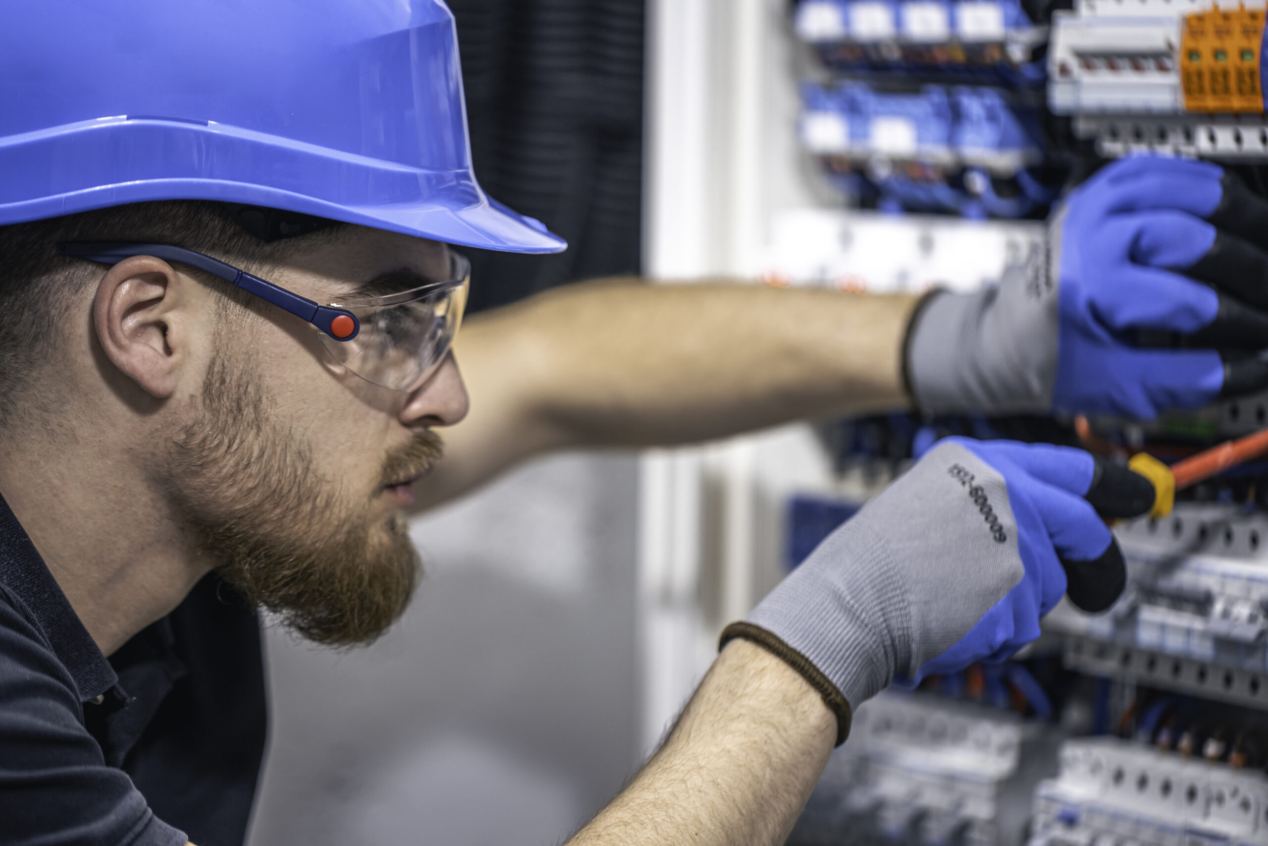 male-electrician-works-switchboard-with-electrical-connecting-cable